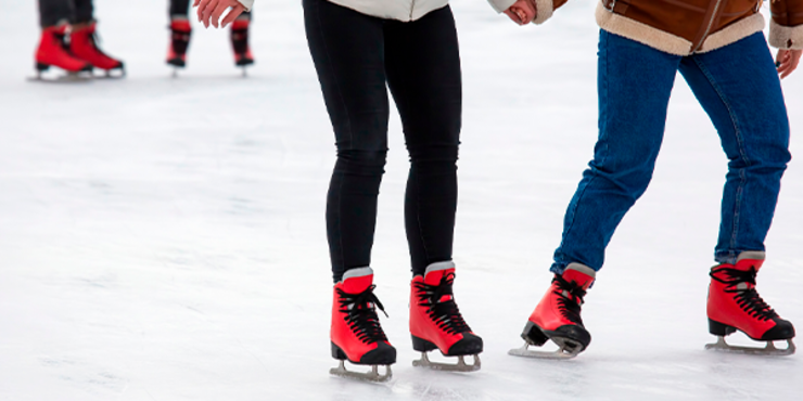 cenário com os pés de casais patinando no gelo um ao lado do outro 